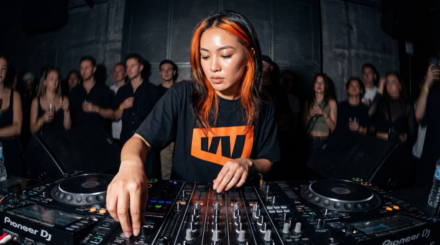 DJ with orange hair wearing a Workflow T-shirt